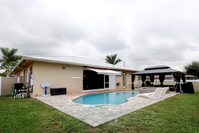 back of house with fence, a gazebo, stucco siding, a yard, and a patio area