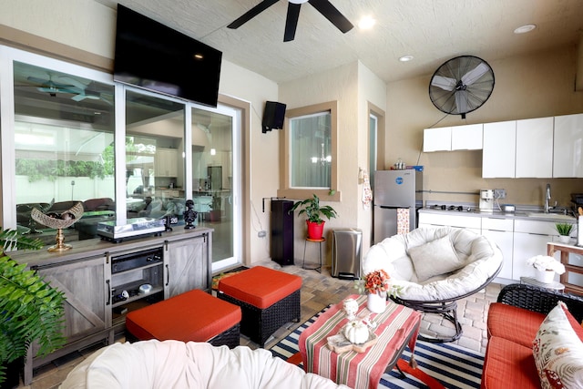 living room with a textured ceiling and ceiling fan