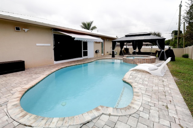 view of pool featuring a gazebo, fence, a pool with connected hot tub, and a patio