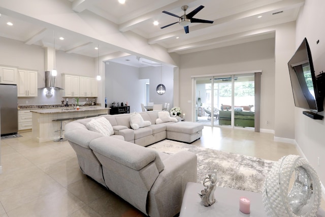 living room featuring beam ceiling, visible vents, baseboards, and light tile patterned floors