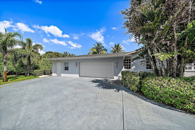 ranch-style house with stucco siding, driveway, and an attached garage