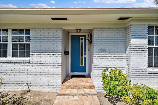 view of exterior entry featuring brick siding