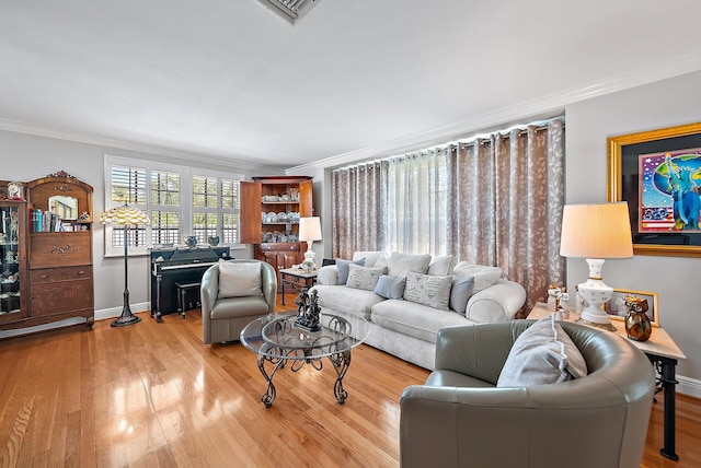 living area with visible vents, ornamental molding, baseboards, and wood finished floors