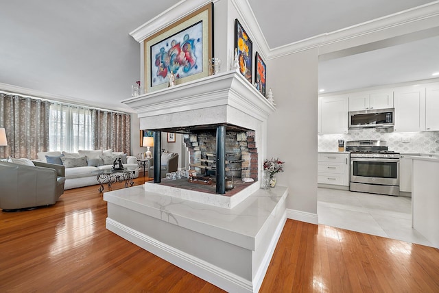 living room with baseboards, light wood-style floors, and crown molding