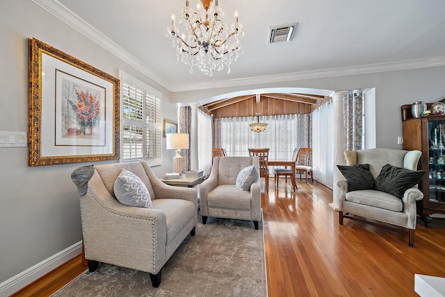 sitting room featuring crown molding, decorative columns, visible vents, and arched walkways