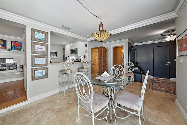 dining area featuring crown molding, ceiling fan with notable chandelier, visible vents, and baseboards