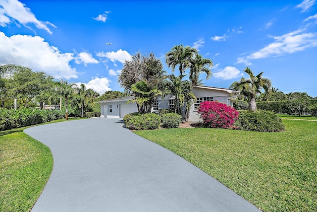 single story home featuring a garage, driveway, and a front lawn