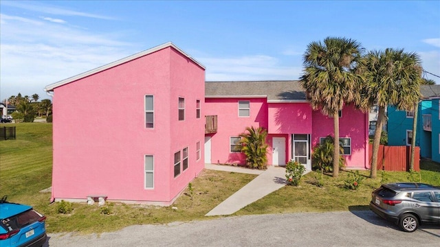 multi unit property featuring stucco siding and a front yard