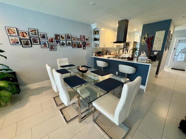 dining area featuring light tile patterned floors and baseboards