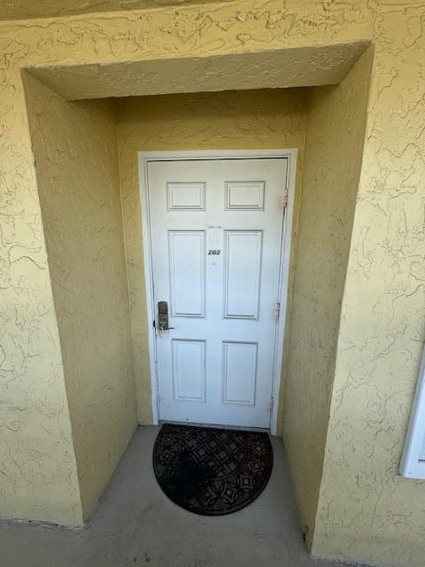 property entrance with stucco siding