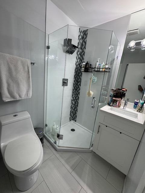 bathroom featuring vanity, toilet, and a shower stall