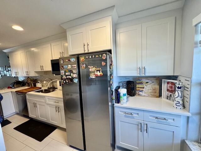 kitchen with white cabinetry, tasteful backsplash, appliances with stainless steel finishes, and a sink