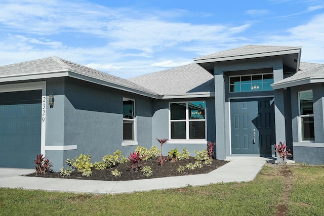 entrance to property featuring stucco siding, an attached garage, and a shingled roof