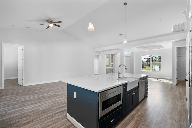 kitchen with open floor plan, wood finished floors, visible vents, and a sink