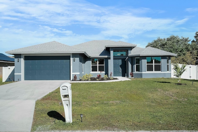 prairie-style home featuring a front lawn, fence, a garage, and stucco siding