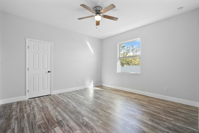 unfurnished room with a ceiling fan, wood finished floors, and baseboards