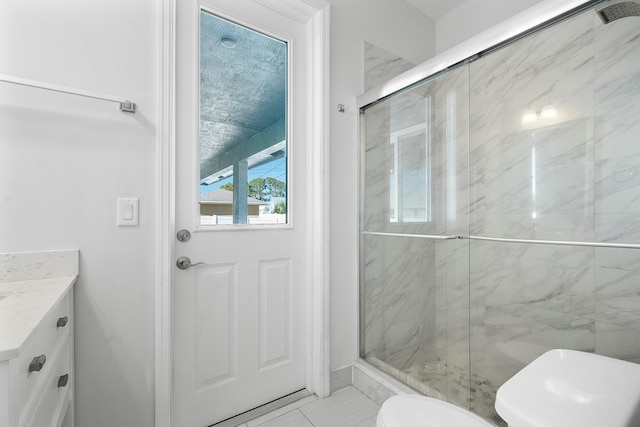 bathroom featuring vanity, toilet, and a marble finish shower