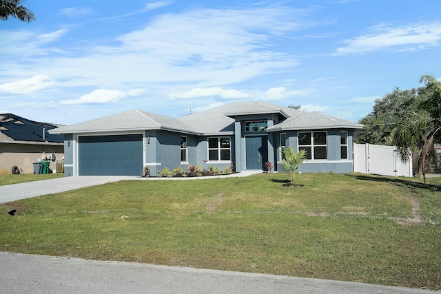 prairie-style home featuring a front yard, a gate, stucco siding, concrete driveway, and a garage