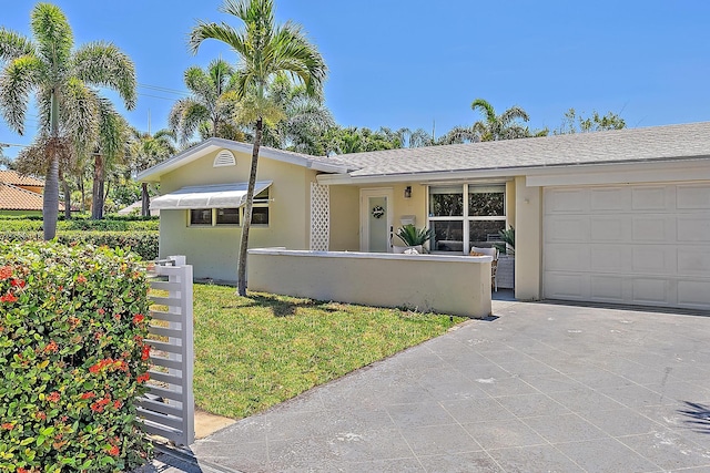 view of front of home featuring an attached garage, fence, and stucco siding