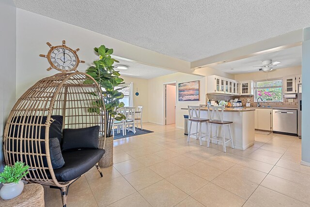 kitchen featuring a breakfast bar, decorative backsplash, white cabinets, glass insert cabinets, and dishwasher