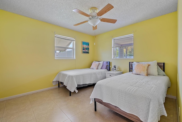 tiled bedroom featuring baseboards, a textured ceiling, and ceiling fan