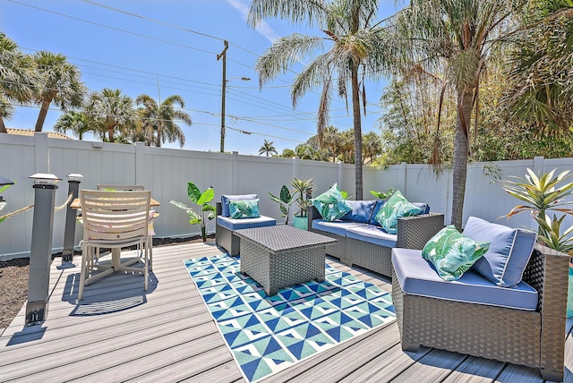 wooden deck with outdoor lounge area and a fenced backyard