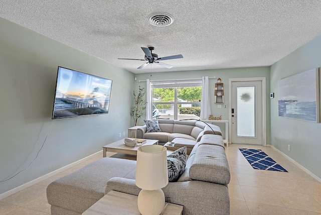 tiled living room featuring visible vents, baseboards, a textured ceiling, and ceiling fan