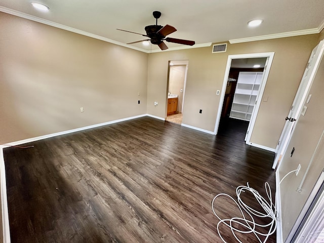 unfurnished bedroom featuring baseboards, visible vents, dark wood-style flooring, a spacious closet, and crown molding