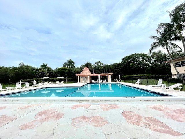 pool with a patio area and fence