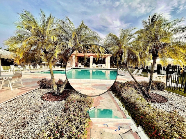 pool with a patio and fence