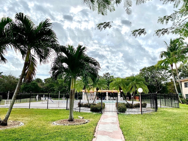 view of community featuring fence and a lawn