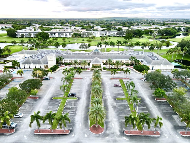 birds eye view of property with a water view and view of golf course