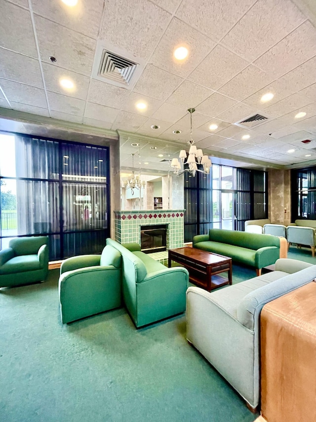 carpeted living area with a tiled fireplace, visible vents, and recessed lighting