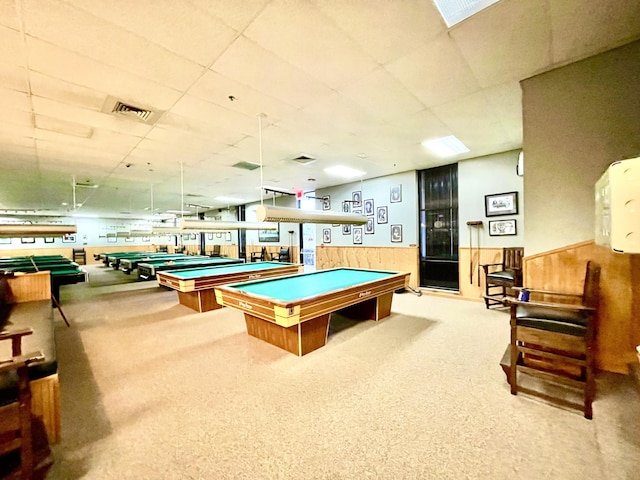 game room with visible vents, wainscoting, a paneled ceiling, and wooden walls