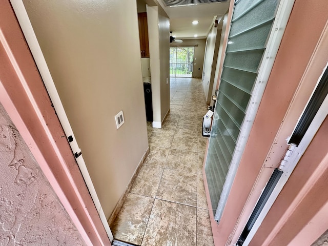 hall with light tile patterned floors and baseboards