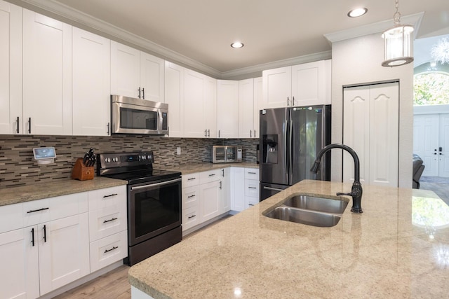 kitchen featuring a sink, light stone counters, backsplash, appliances with stainless steel finishes, and white cabinets