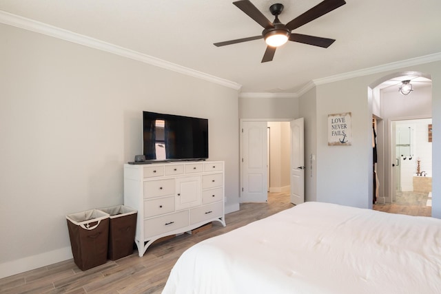 bedroom featuring baseboards, light wood finished floors, arched walkways, ceiling fan, and ornamental molding