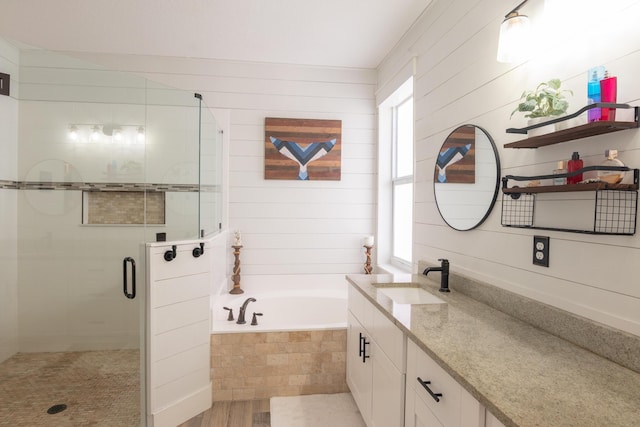 full bath featuring vanity, a healthy amount of sunlight, a bath, and a shower stall