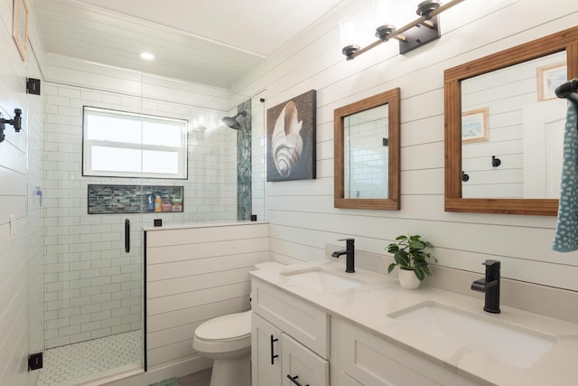bathroom with double vanity, toilet, a stall shower, and a sink