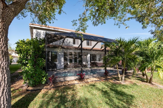 rear view of property with a lanai, a tile roof, a yard, an outdoor pool, and a patio