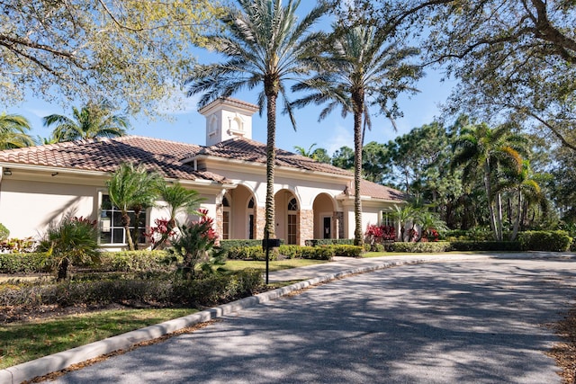 mediterranean / spanish-style home featuring a tile roof and stucco siding