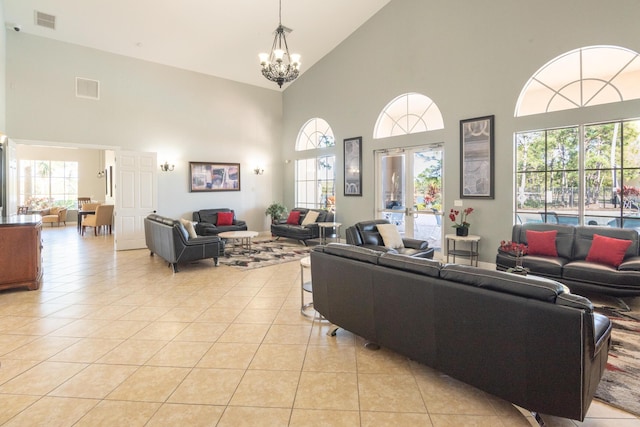living area featuring visible vents, a notable chandelier, light tile patterned flooring, and high vaulted ceiling