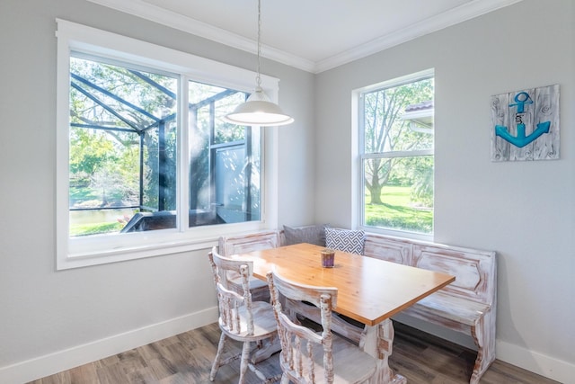 dining area featuring crown molding, wood finished floors, baseboards, and a wealth of natural light