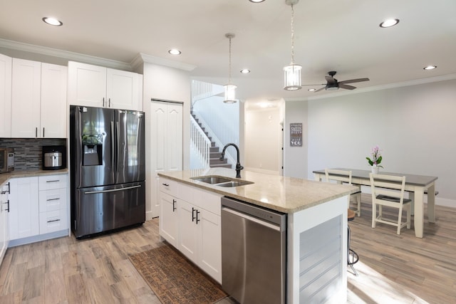 kitchen featuring a ceiling fan, a sink, dishwasher, crown molding, and fridge with ice dispenser
