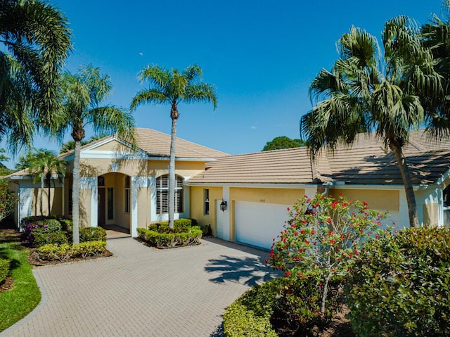 view of front of house featuring a garage, decorative driveway, and stucco siding