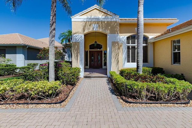 property entrance with stucco siding and french doors