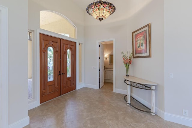 entryway featuring a high ceiling and baseboards