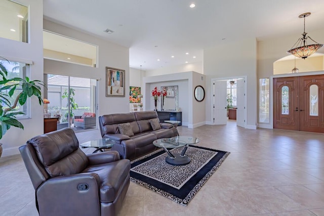 living room featuring light tile patterned floors, visible vents, baseboards, recessed lighting, and a towering ceiling