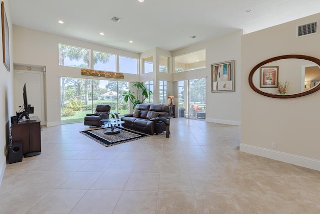 living area featuring a high ceiling, recessed lighting, baseboards, and visible vents