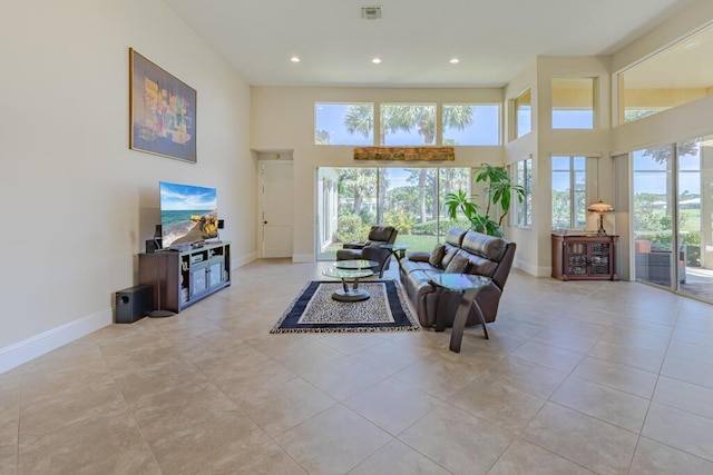 living room with visible vents, recessed lighting, baseboards, and a towering ceiling